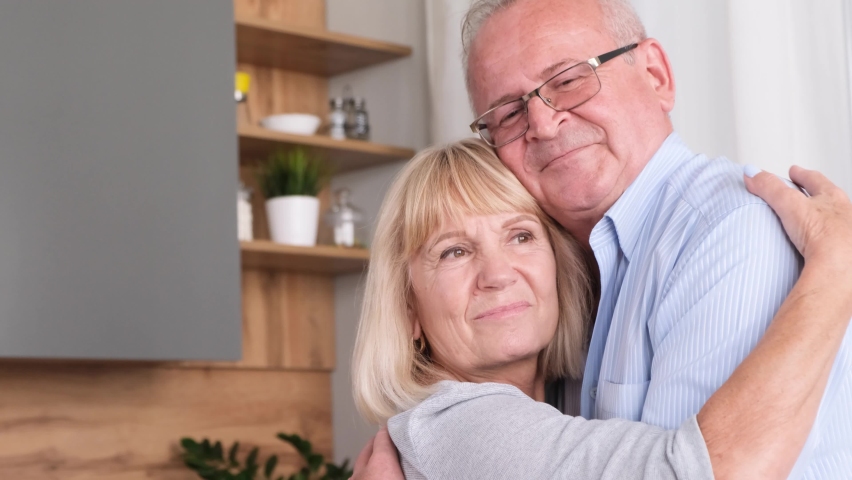 Happy senior couple dancing at home in the kitchen, they are laughing and hugging while relaxing Royalty-Free Stock Footage #1092187509