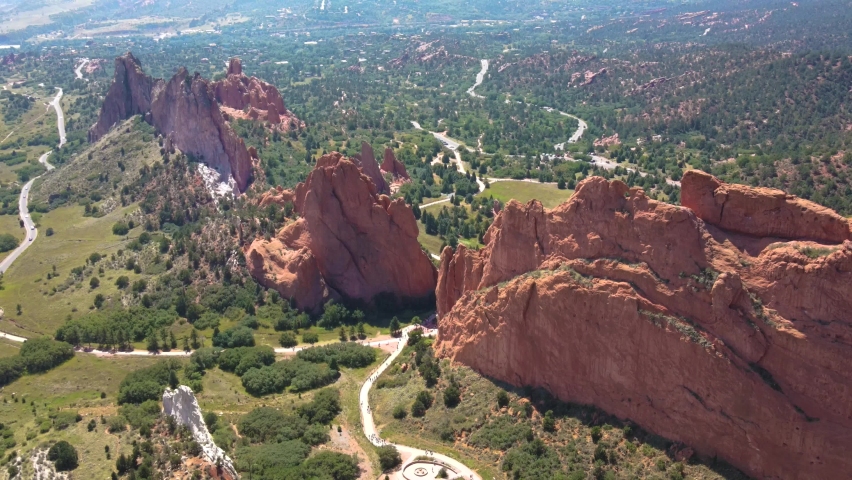 Aerial drone shot flying around Garden of the Gods rock formations with mountain silhouettes in background in Colorado Springs, Colorado, USA