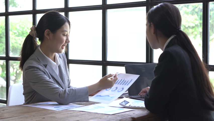 Two female business people discussing in office desk, tax and financial business concept. Royalty-Free Stock Footage #1092191675