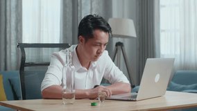 Asian Man Cheering And Drinking Vodka During Having Video Call On A Laptop At Home
