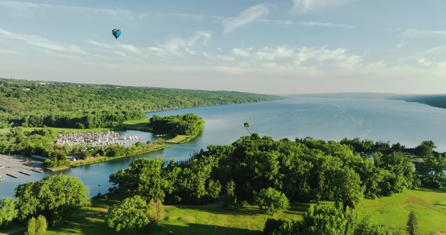 Ithaca NY USA June 26, 2022: Beautiful Hot Air Balloon near traveling over the  Cayuga Inlet and Cayuga Lake on a sunny Sunday morning
