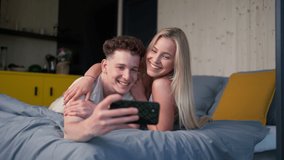 Young happy couple in love lying in bed in morning in their new home in tiny house,taking selfie, sustainable living concept. - Powered by Shutterstock - Get 15% off with code: PIKWIZARD15