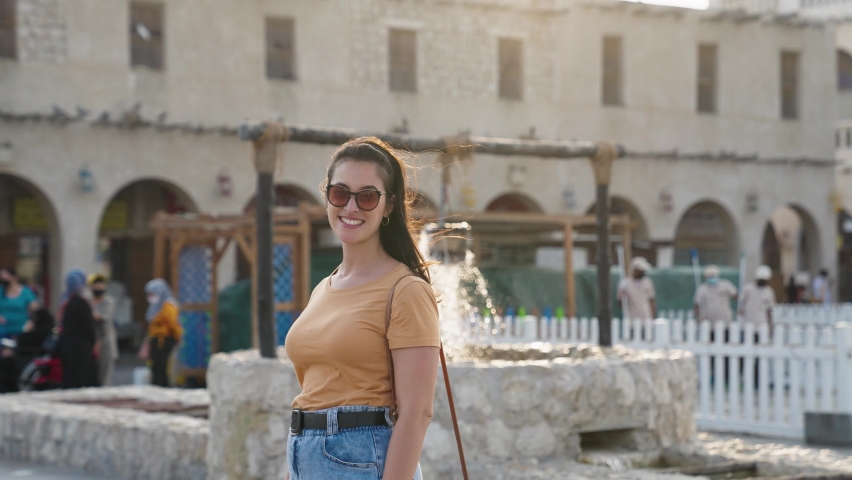 Happy female tourist smiling and looking at camera at Souq Waqif in Doha Qatar
