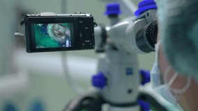 Close-up dental microscope screen with tooth cavity and blurred doctor on the right. Unrecognizable professional dentist using modern device for endodontic treatment in medical clinic. Slow motion - Powered by Shutterstock - Get 15% off with code: PIKWIZARD15