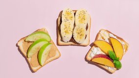 Set of toasted bread with peach, apple and banana on pink background. Stop Motion Animation.