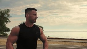 Athletic Man training Outdoors with a Barbell Plates. Bodybuilder training on the beach.Slow Motion