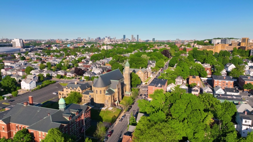 Brighton historic center and St Columbkille's Parish Church aerial view with Boston Back Bay skyline at the background in city of Boston, Massachusetts MA, USA. 