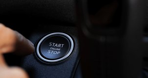 A Caucasian Man hand presses the engine start button in a luxury off road suv in a sunny day under the forest, slow motion video, closeup shot, 4+ resolution, Apple prores file