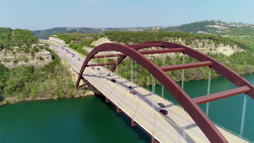 Flying above the Pennybacker Bridge in Austin, Texas flying towards hillside.