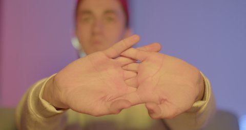 A man does a warm-up of fingers and hands before a video game. It pulls the palms in the castle, increases tone and strength. Ready to start playing.