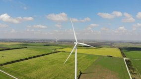 Panoramic aerial view. Landscape of Southern Ukraine before russian occupation. The coast of the Sea of Azov. Green agriculture fields, blue sea and sky. Wind power plant, windmills. 4K video
