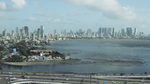 A wide panning shot which goes from Mahim, Dadar side to Worli, Bandra Sealink side with traffic at the bottom