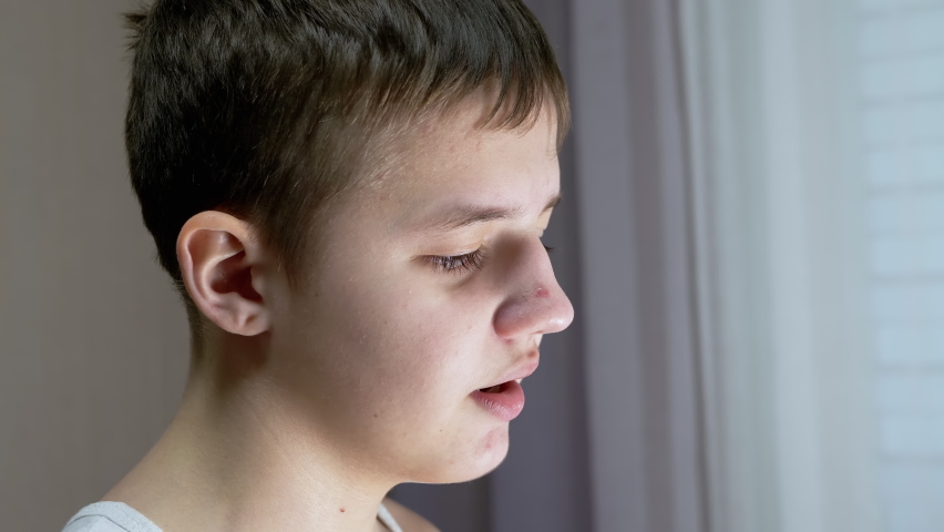 Close-up of a Face Profile of Talking Smiling Teenager Looking Down. Side View. Dialog. Mouth, lips movement. Conversation, Guilt, remorse. Gesture. Facial expression. Part of face. Behavior, emotion. | Shutterstock HD Video #1092238685