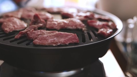 Cooking delicious beef with a gas stove. Cook beef meat on grilled meat. Food cooked with grilling barbecue inside house