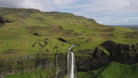 Seljalandsfoss waterfalls in Iceland with drone video moving out.