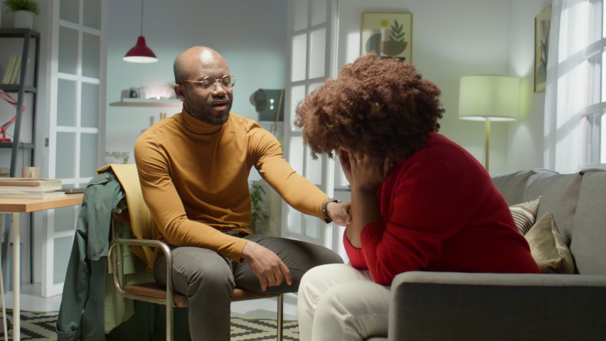 Zoom in shot of loving African American husband holding hand and talking to crying wife at home while supporting her in tough time Royalty-Free Stock Footage #1092241701