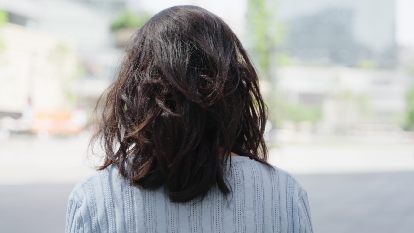Slow motion of Charming young asian woman turn back looking at camera smile in the summer city 