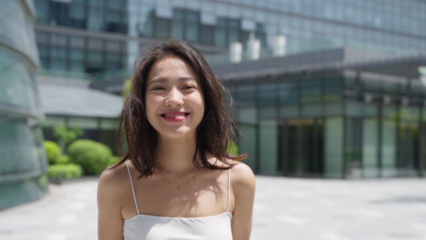 Charming young asian woman looking at camera smile in the summer city slow motion say love you cute girlfriend