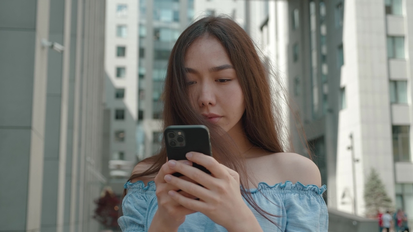 Shocked frustrated asian woman student feel stressed look at smartphone screen worried of problem read bad online news receive failed exam results concept standing in outdoor Royalty-Free Stock Footage #1092250471