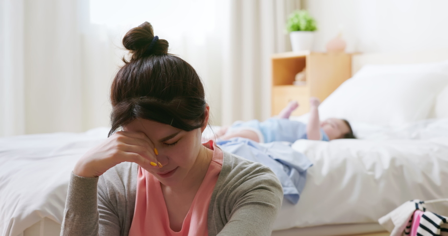 authentic shot of asian mother has postpartum depression with her baby who is lying on bed Royalty-Free Stock Footage #1092259355