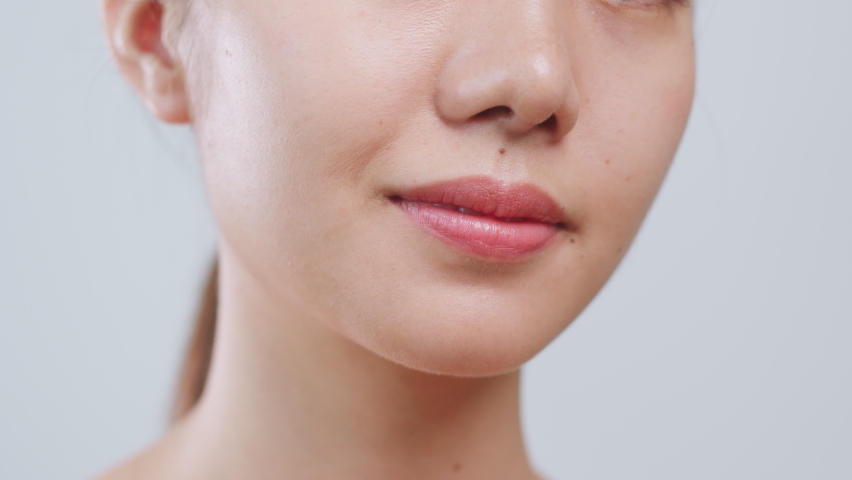 Portrait young Asian woman show v shape face after botox injection over grey background, beauty skin concept