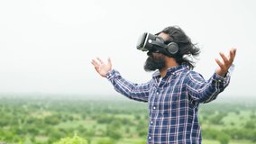 man with VR headset feeling nature by stretching arms on top of hill - concept of Metaverse, virtual reality and futuristic. - Powered by Shutterstock - Get 15% off with code: PIKWIZARD15