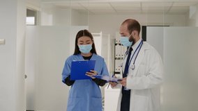 African american woman talking to physician at hospital reception during covid 19 pandemic. Diverse people with face masks doing consultation about coronavirus prevetion in waiting area. - Powered by Shutterstock - Get 15% off with code: PIKWIZARD15