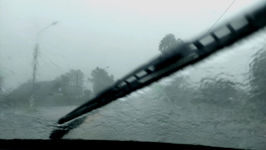 in the car to drive in heavy rain, wipers clean the windshield glass Royalty-Free Stock Footage #1092274527