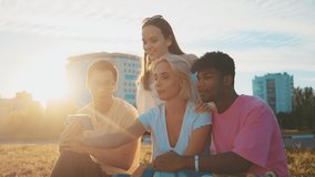 Beauty Young multi-ethnic hipster friends on summer video chatting using smartphone at beach. Four young multiracial people spending time together. Friendship, communication, youth a lifestyle concept