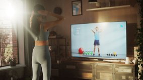 Active Girl Watching Personal Trainer through Online Video Tutorial while Training at Home. Strong Athletic Fit Woman Using Technology, Streaming Service Fitness Subscription for Virtual Training