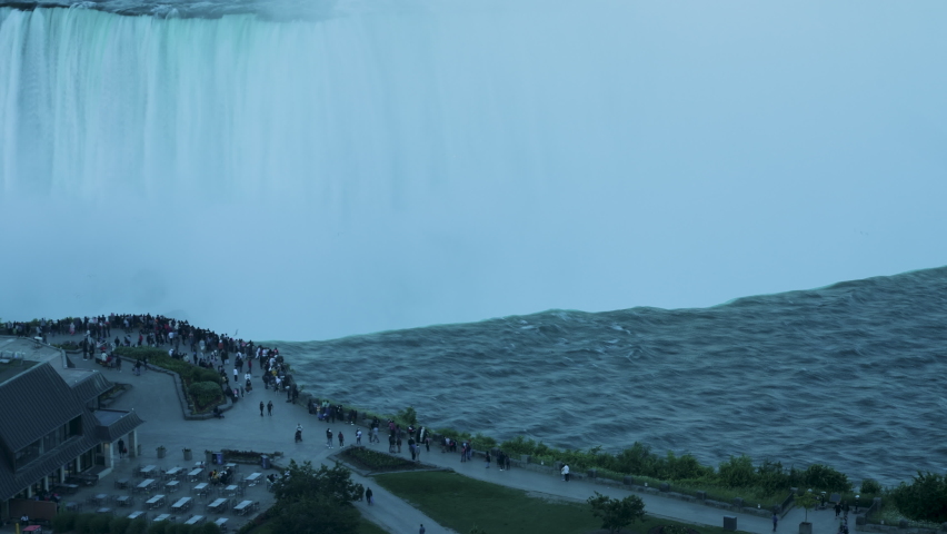 Evening close-up timelapse shot of people gathering near the edge of Horseshoe Falls in Niagara Falls, Ontario.