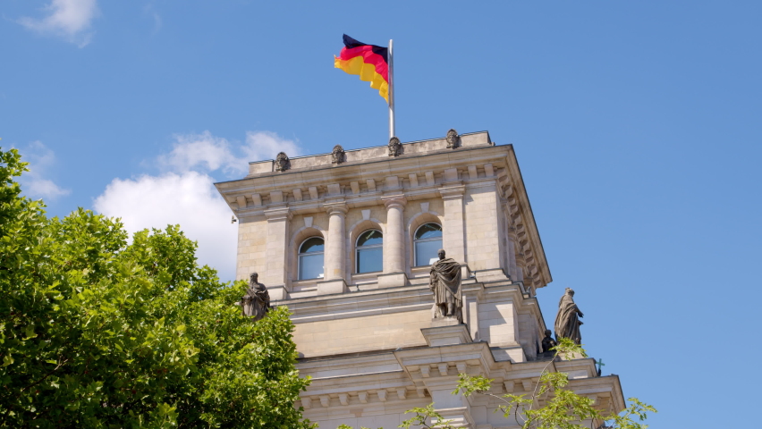 Detail of Reichstag Building in Berlin and Waving German National Flag
