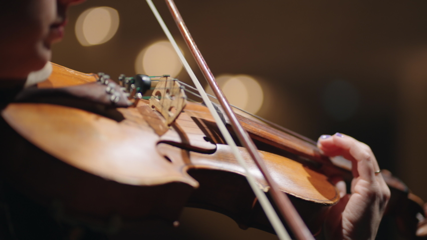 closeup of old violin in hands of woman, female musician is playing violin and rehearsing sonata in music hall Royalty-Free Stock Footage #1092289833