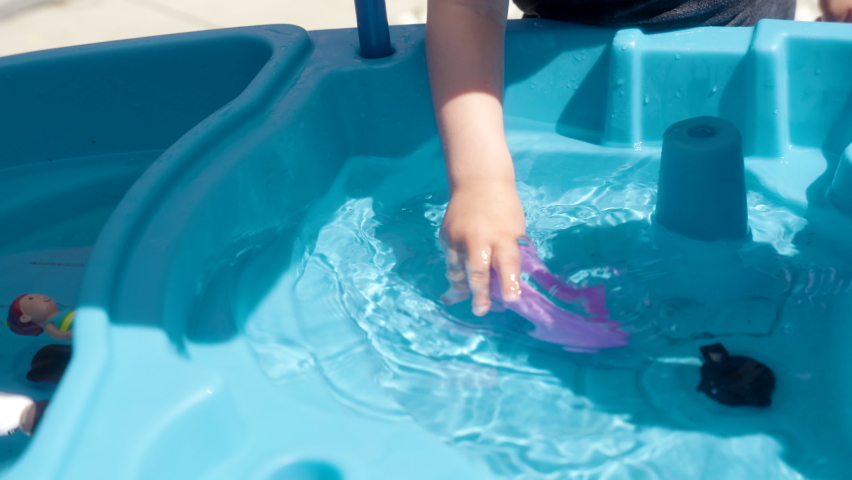 A kid playing with a toy boat.