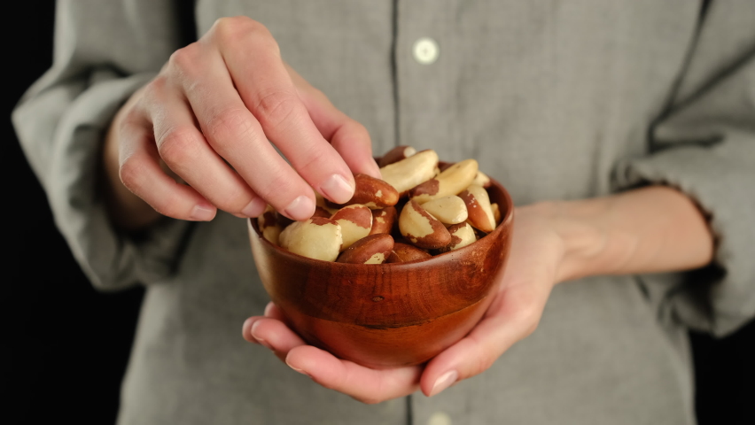 Female hold brazilian nuts in hand. 