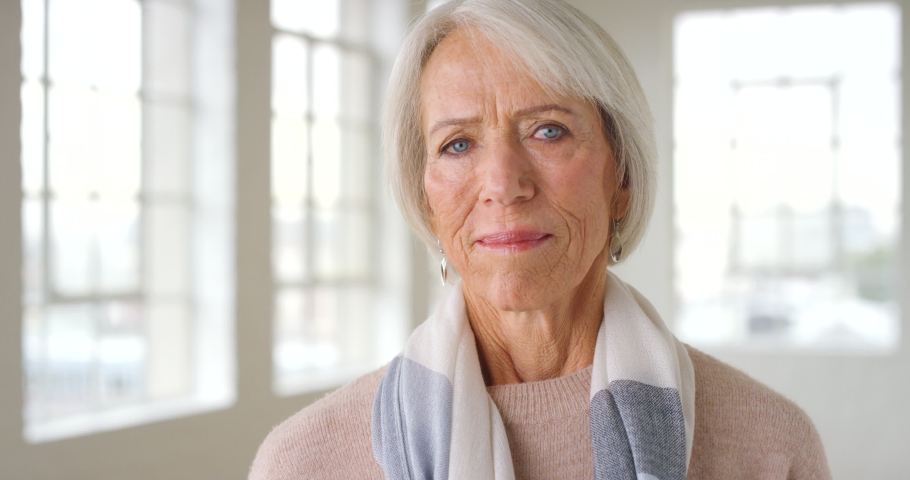 Portrait of a senior business woman standing inside a building with bright light and copy space. Beautiful and stylish mature caucasian lady with grey hair smiling indoors with copyspace Royalty-Free Stock Footage #1092297111