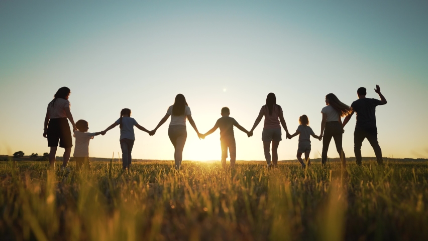 Big happy family. Group of people have fun walking in the park on green grass. Parents and children walk together holding hands at sunset. Family love and support. Family teamwork in park on vacation Royalty-Free Stock Footage #1092300081