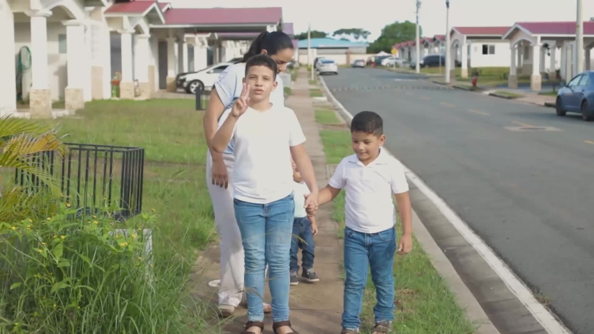child with white sweater walking holding hands