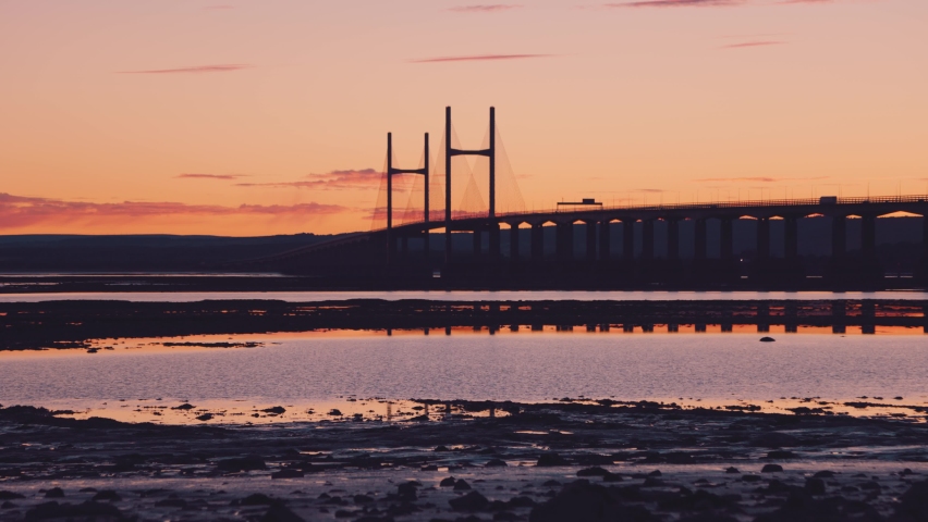 Cars driving over Severn Bridge at sunset, Bristol, UK