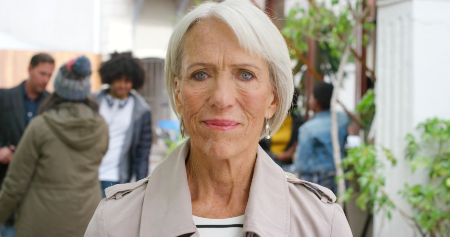 Portrait of a happy senior business woman during rush hour after work. Confident old female in a busy street in a city or town with a bright smile. Beautiful and stylish happy aged lady outdoors Royalty-Free Stock Footage #1092305231