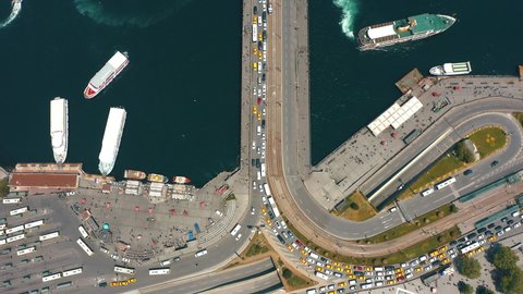 Aerial top down of Eminonu square and Galata Bridge over Bosphorus in Istanbul, Turkey. Boats and ships on water, Seagull flying, Car Traffic, Tram line, drone view, transportation