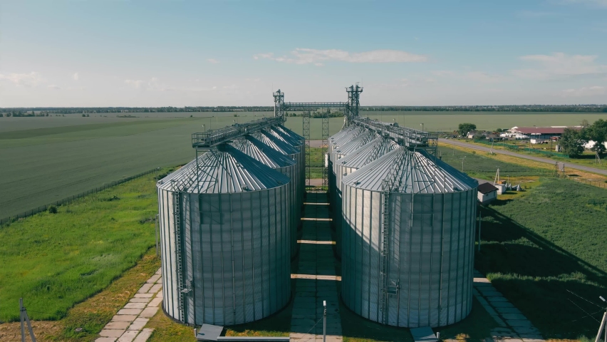 Complex of grain elevator buildings. Metal Round Silos and Metal Barrels for Grain Storage. Drying Storage Harvest. Elevator Tanks and Grain-drying complex. Large Granary Royalty-Free Stock Footage #1092309237