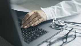 Close up of a doctor is working and typing on laptop in a clinic. Physician is filling in patient electronic record and browsing medical history. Concept of healthcare or hospital and medicine. - Powered by Shutterstock - Get 15% off with code: PIKWIZARD15