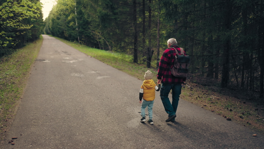 old man with backpack and fishing road is walking and holding hand of his little grandson Royalty-Free Stock Footage #1092315609
