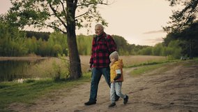 old man and grandchild are spending time together in nature, grandfather and boy on shore of lake - Powered by Shutterstock - Get 15% off with code: PIKWIZARD15