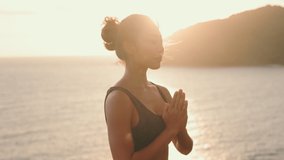 Silhouette of a young Asian woman practicing yoga in prayer pose on the beach during a golden sunset. Concept of mindfulness, meditation, mental health, and spiritual balance. - Powered by Shutterstock - Get 15% off with code: PIKWIZARD15