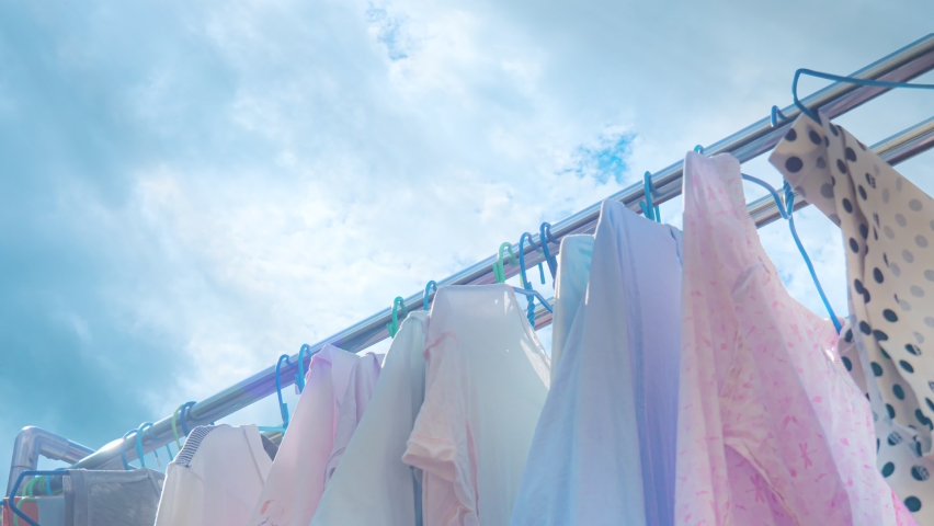 Hang the washed clothes in the sun to dry on a clear day and cloud moving fast timelapse. The clothes were hung in the sun outdoors. Housework on holidays.