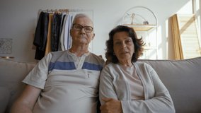 Elderly couple talks on video call via webcam with friends smiling. Senior man and woman distract on grandchildren coming to hug from POV to third party