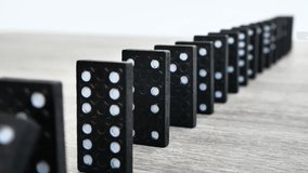 Domino effect in slow motion - falling black tiles with white dots. Dominoes falling in line effect business concept - Powered by Shutterstock - Get 15% off with code: PIKWIZARD15