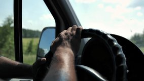Сlose-up video shooting of the steering wheel. A man drives a car and holds the steering wheel with his hands.